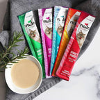 Nulo Freestyle cat food pouches on a marble surface with a bowl of cat food.